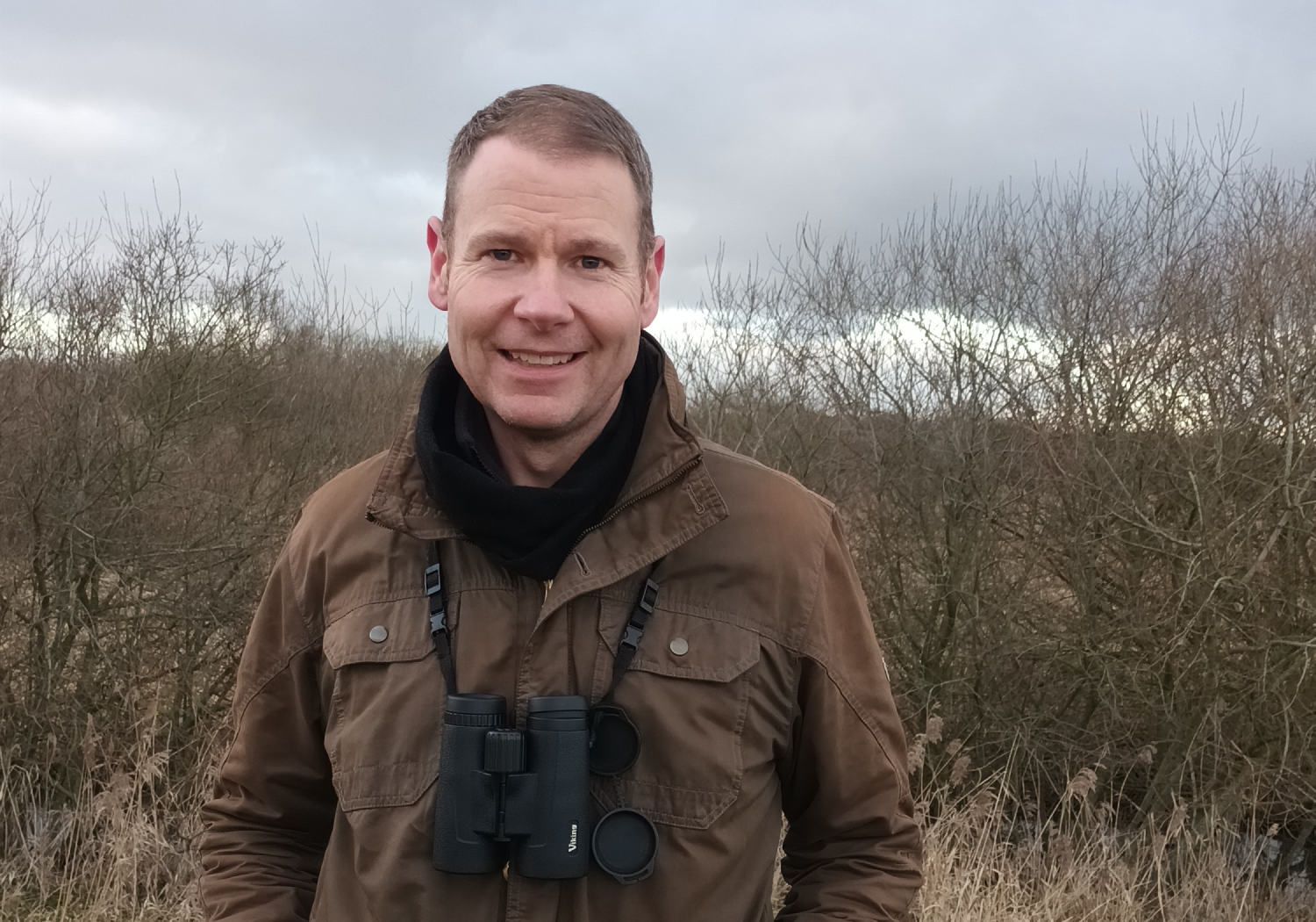 Matt Howard stands with binoculars around his neck