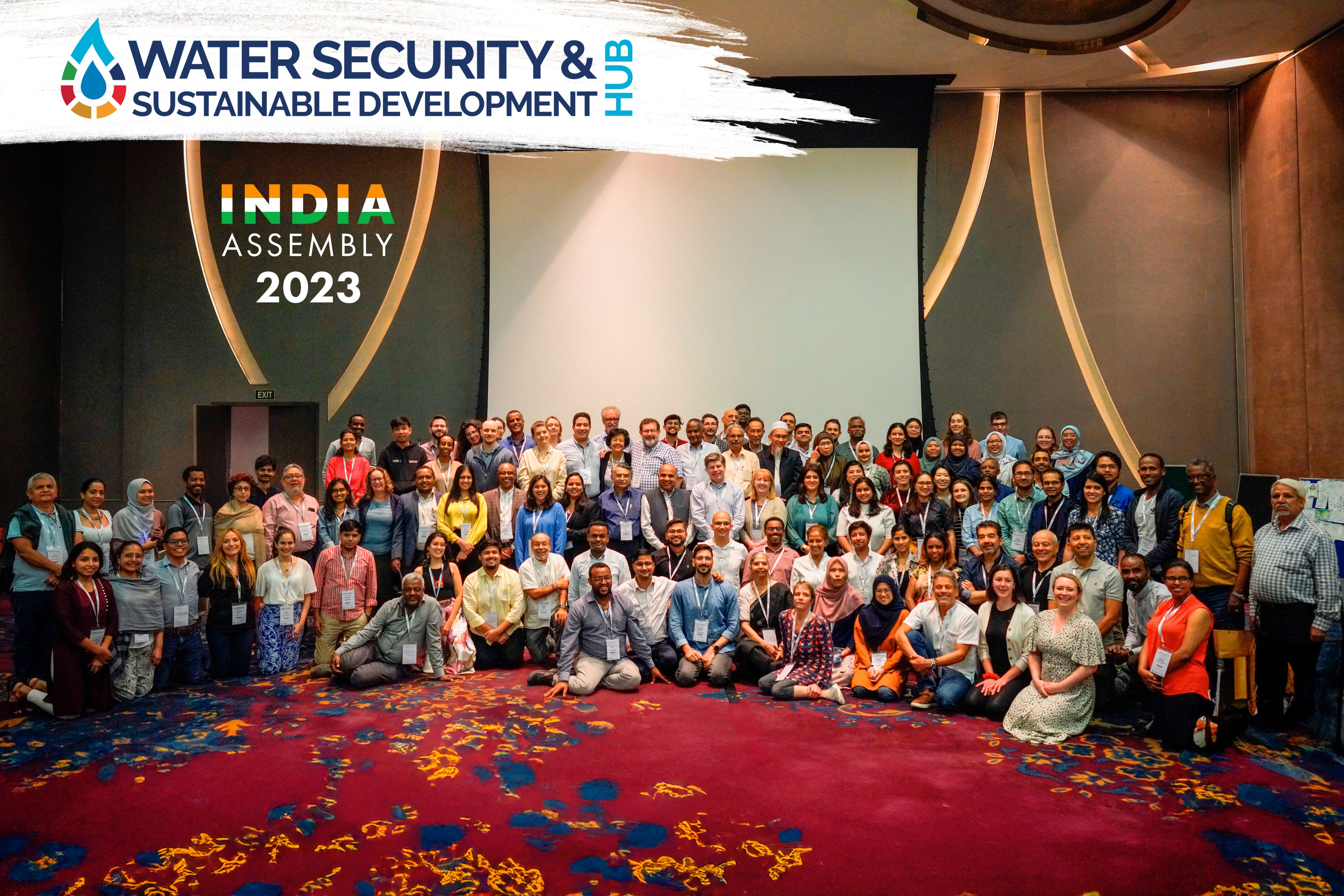 large group of people seated and standing in rows with a banner which says India Assembly 2023.