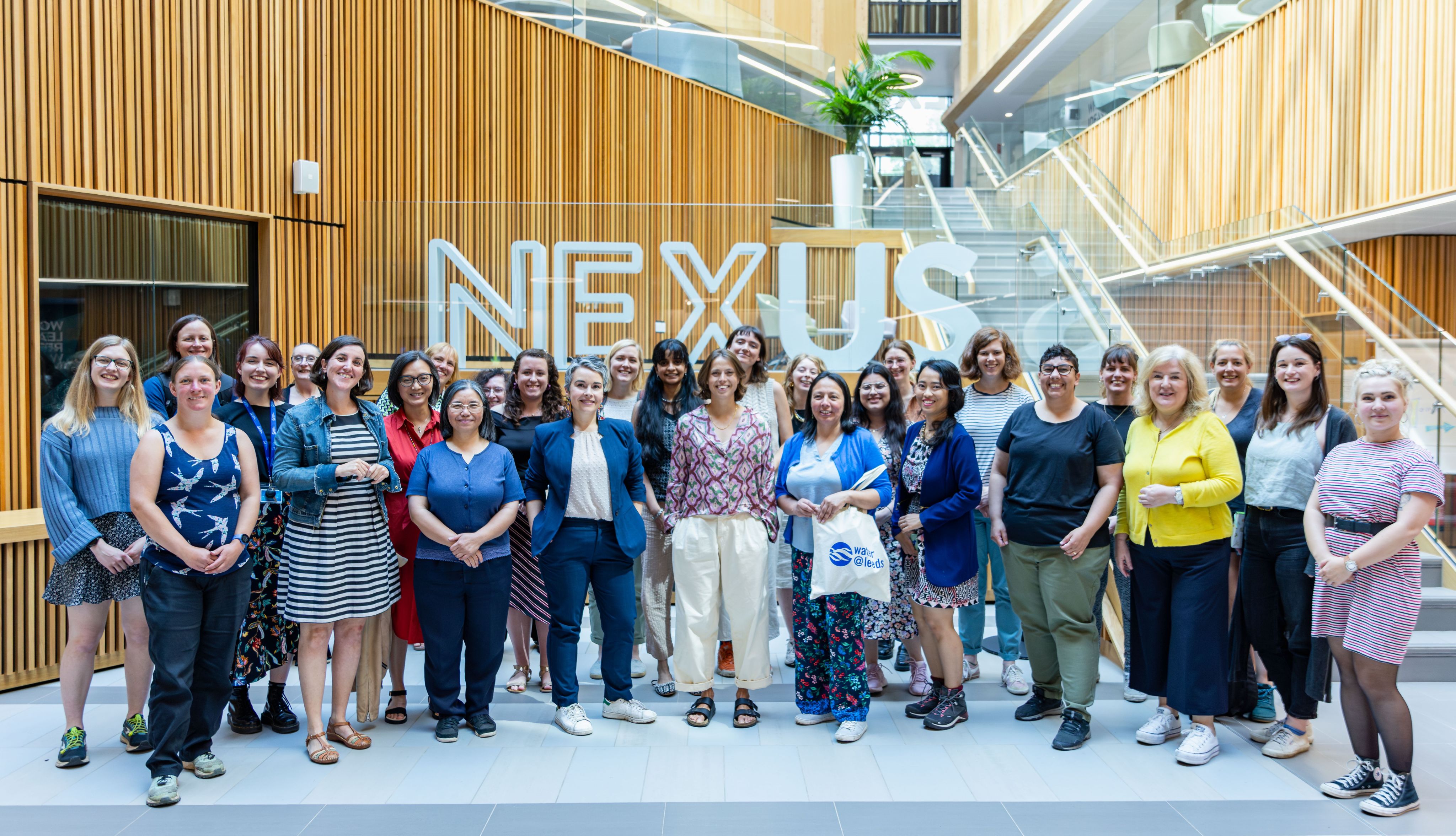 A large group of women in the Nexus building atrium