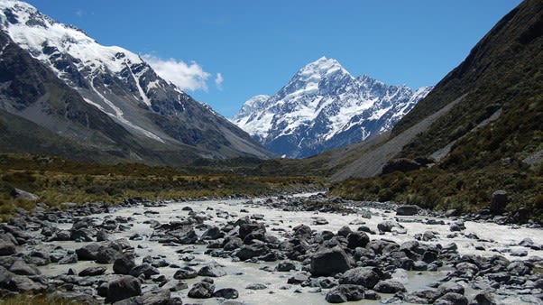 distant snowcapped mountains with a foreground of a rocky river bed.