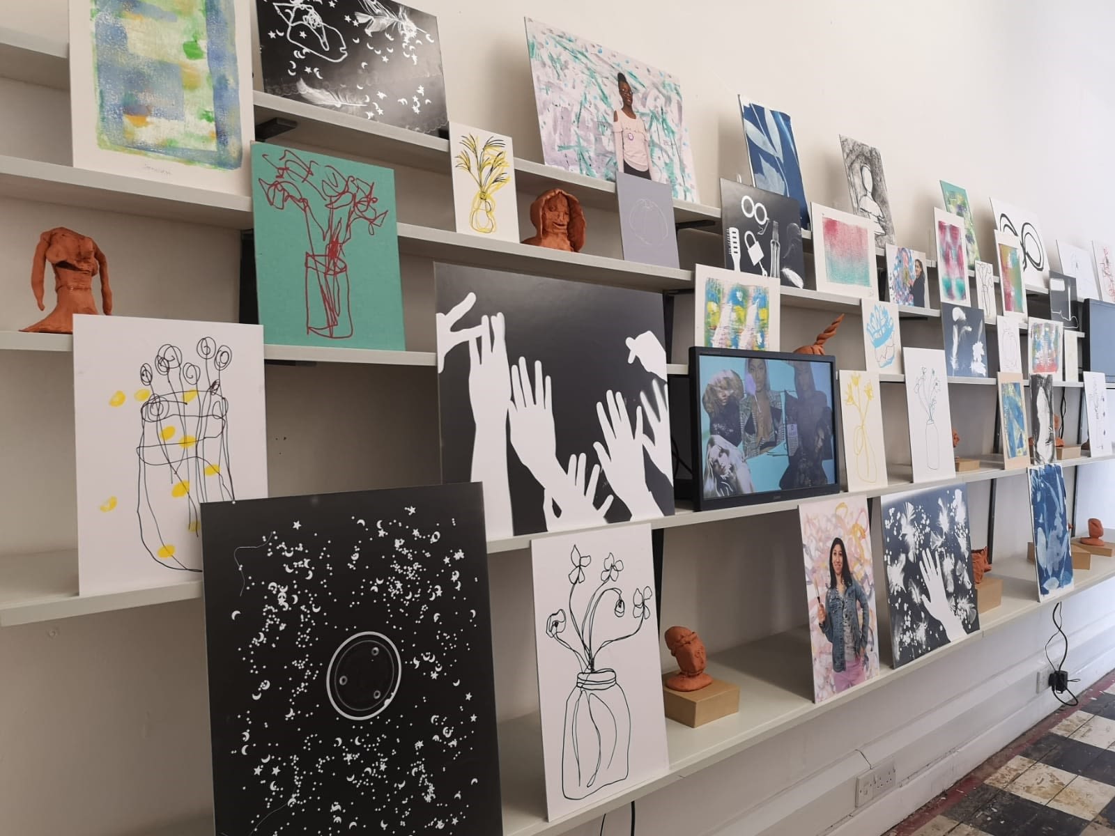 Various artworks on canvases displayed at an Art School for Rebel Girls exhibition