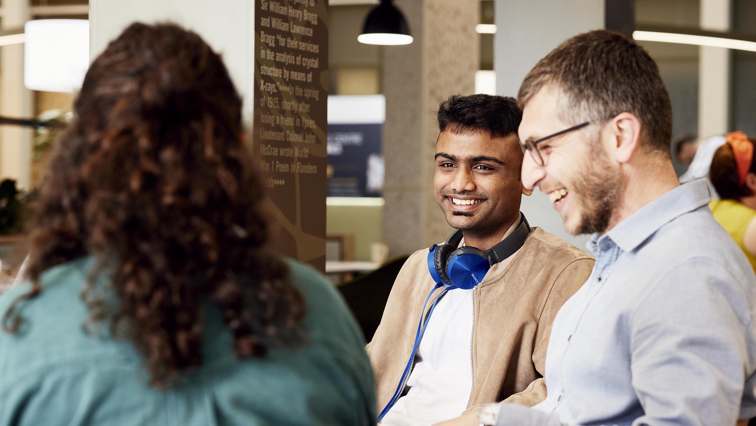 Three students laughing in a cafe