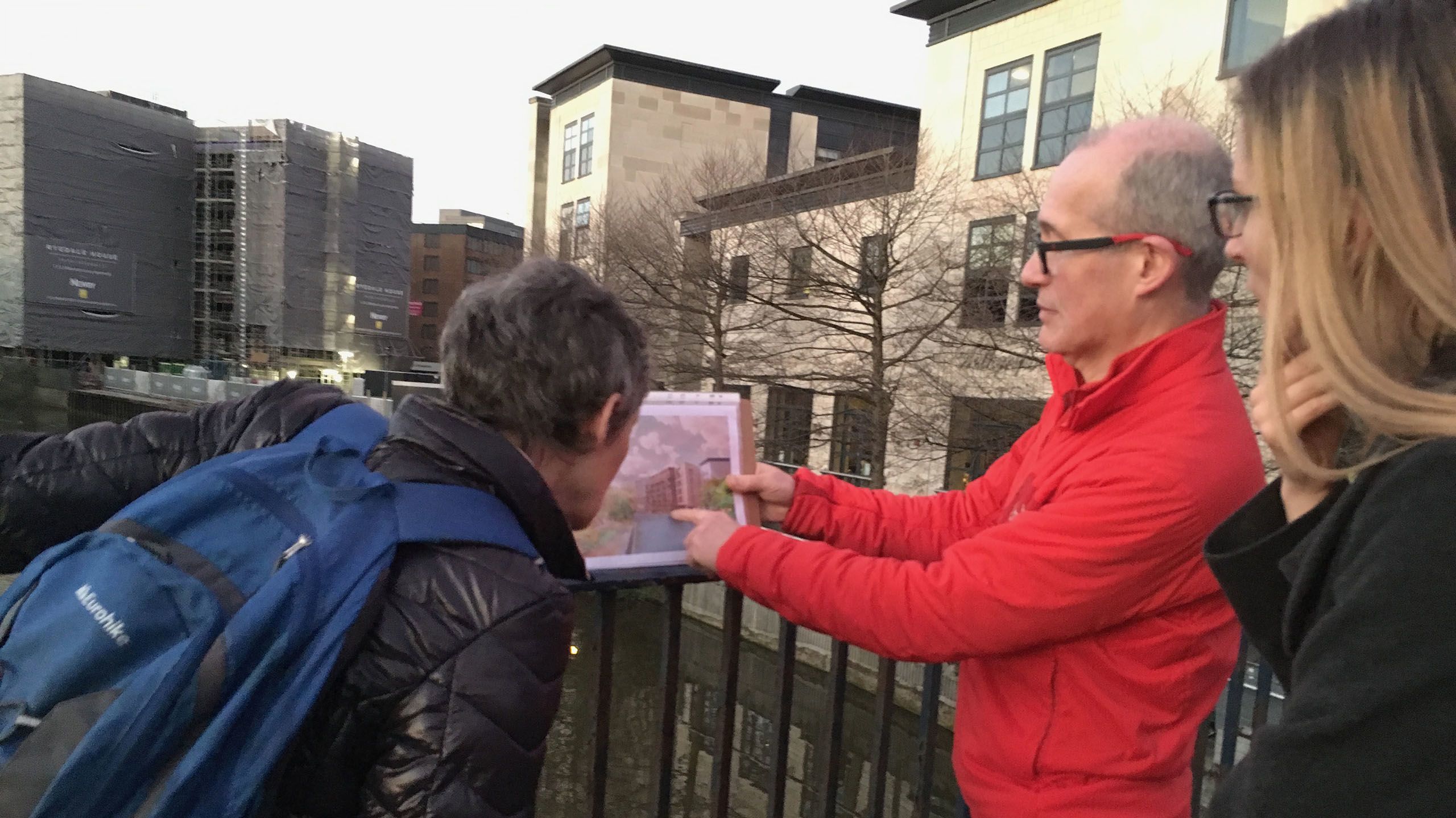 Phil Bixby on a consultation walk showing two people an image of a change to the area