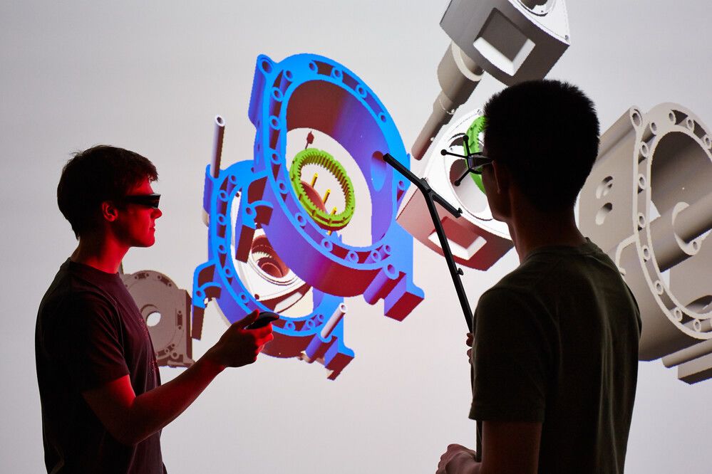 Two students working with with a computer generated model of engineered parts with the Credit: Royal Academy of Engineering Enterprise hub.