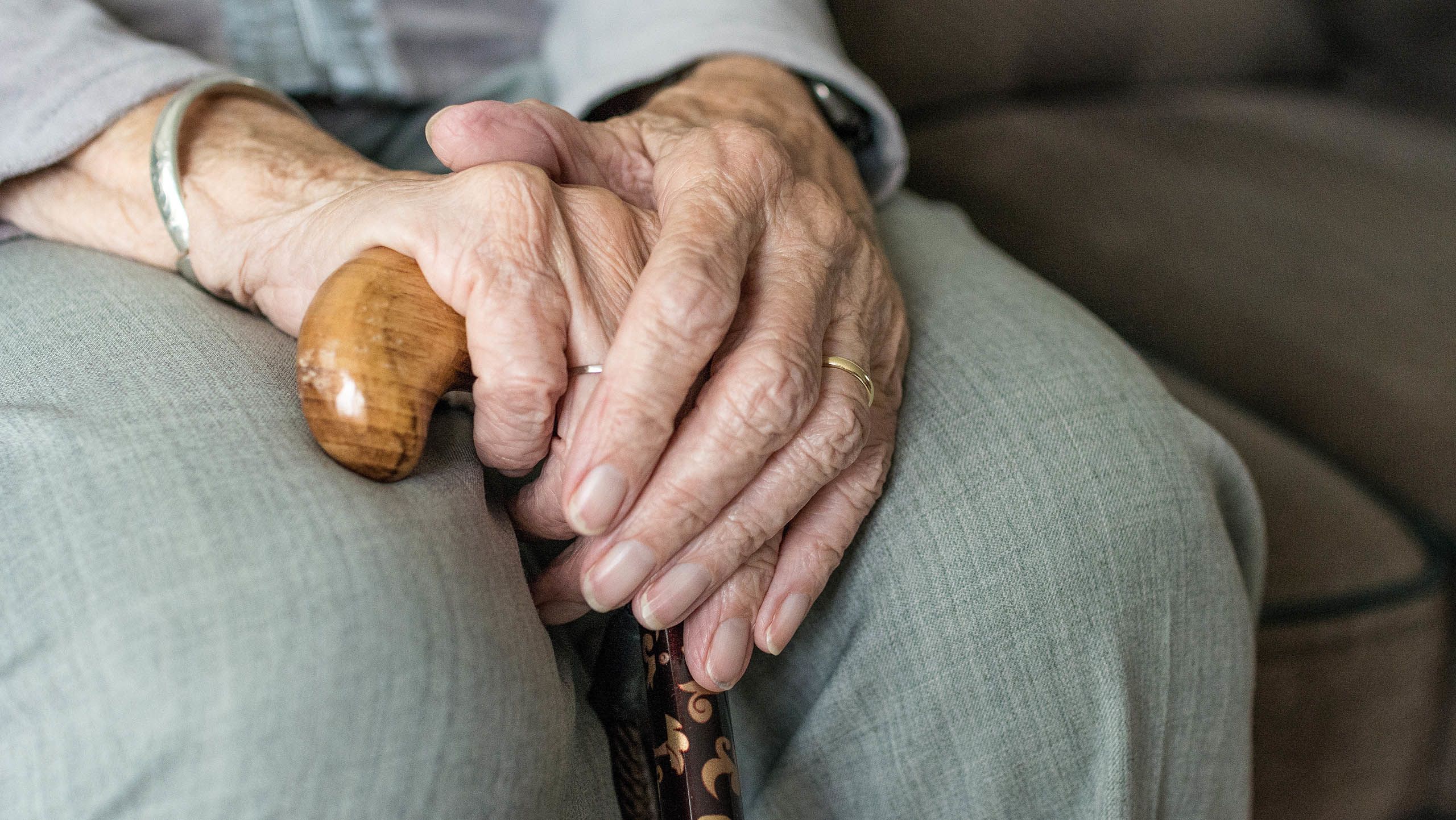Close up of hands holding a walking stick