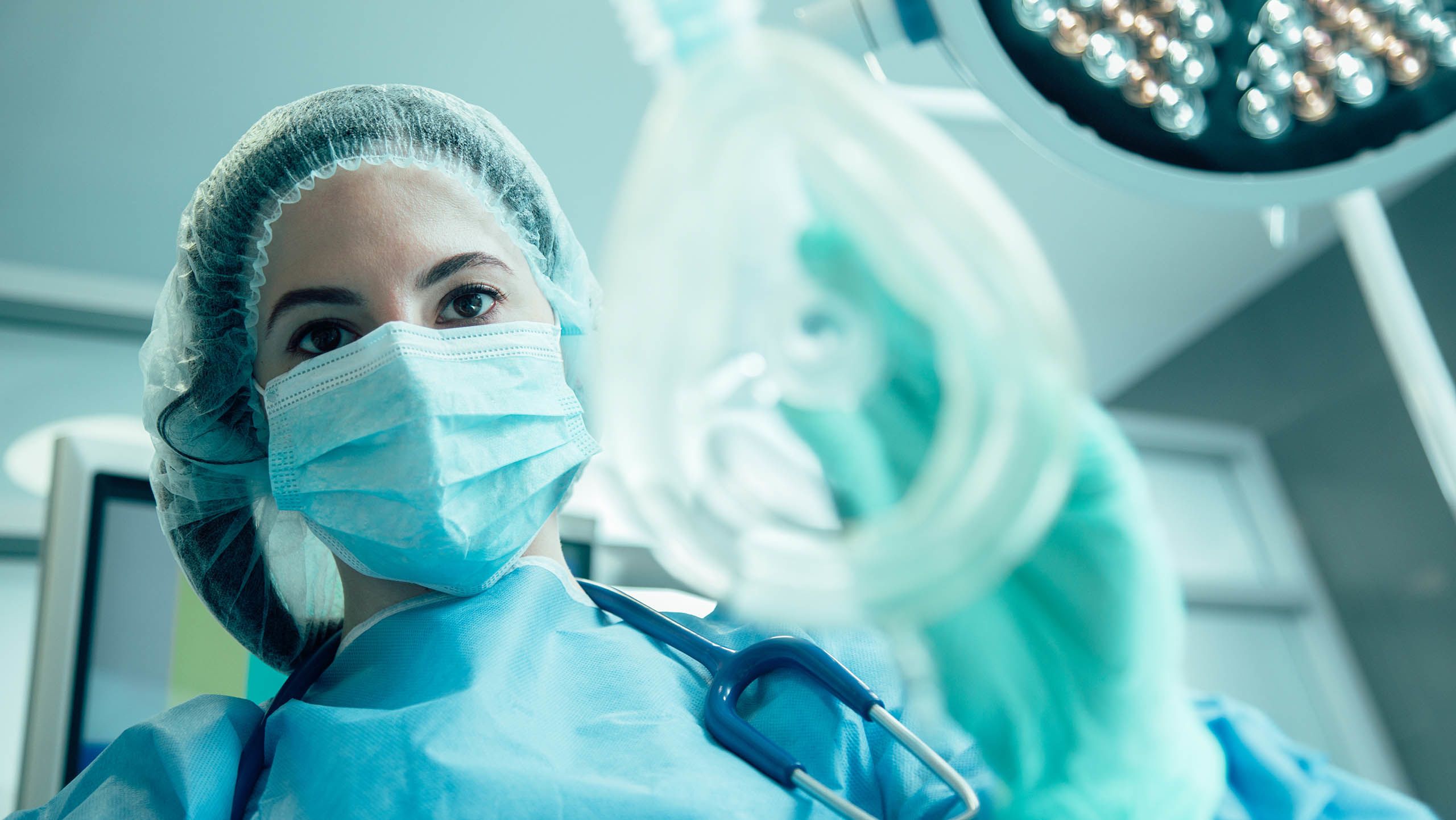 An anaesthetist at work wearing scrubs and a face mask