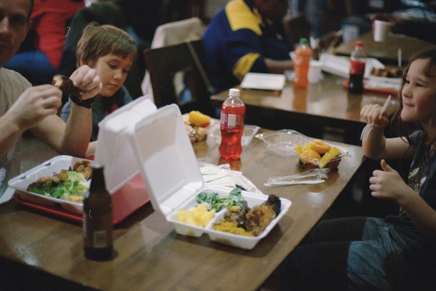 Children eating their school meals at a table in a canteen