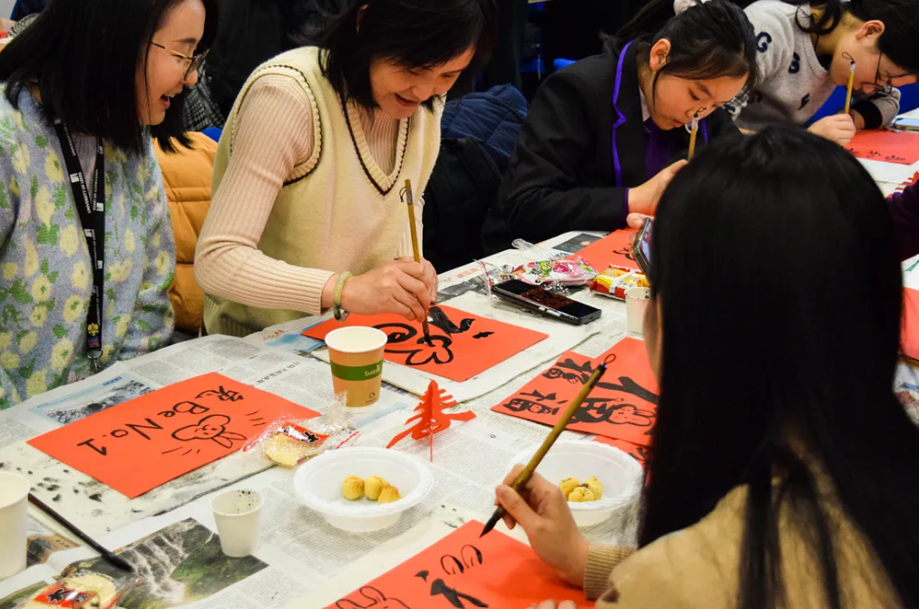 Staff and students writing Mandarin calligraphy at the Confucius Institute