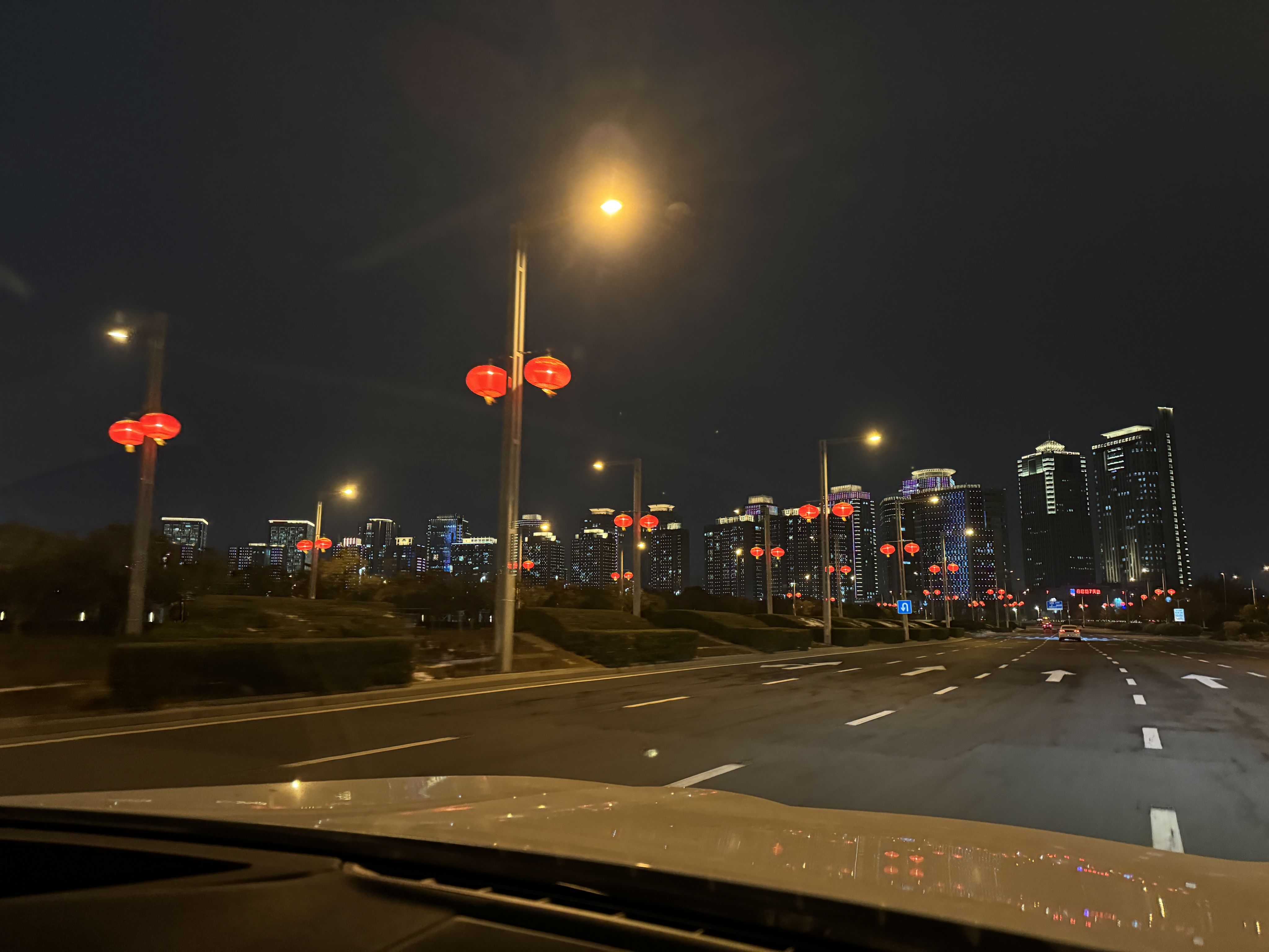 Two students, sat by a window. One is using a mobile phone and the other learning using a tablet.
